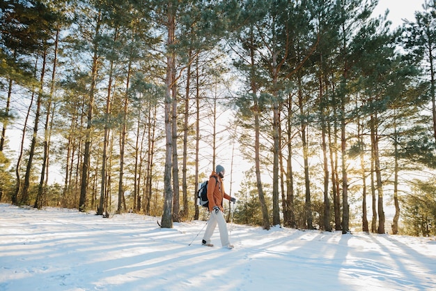 Paysage d'hiver un homme avec un sac à dos et des vêtements d'hiver chauds dans la forêt voyageant dans les montagnes