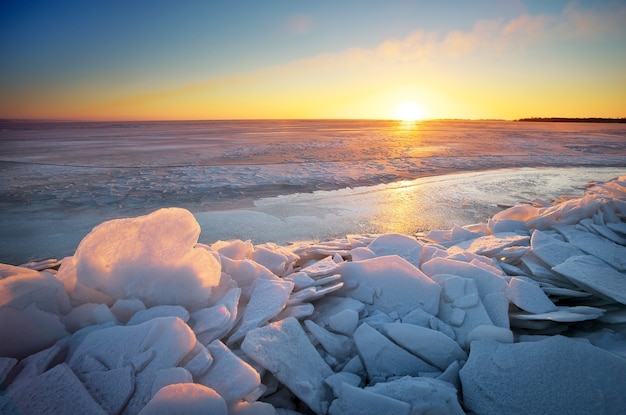 Paysage d'hiver avec lac gelé et ciel coucher de soleil. Composition de la nature.