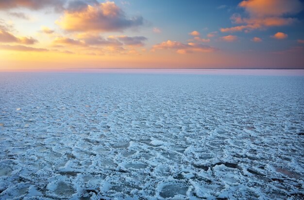 Paysage d'hiver avec lac gelé et ciel coucher de soleil. Composition de la nature.