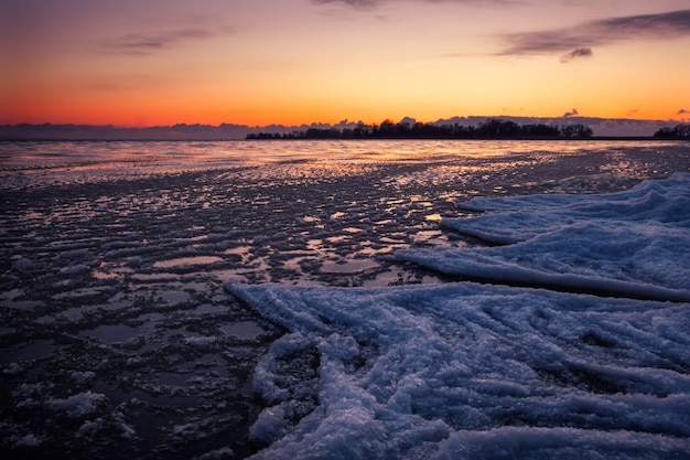 Paysage d'hiver naturel au bord de la mer au coucher du soleil. Ciel de glace et coucher de soleil.