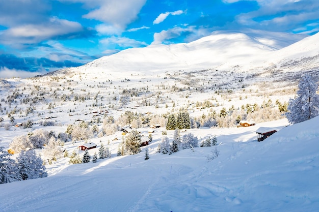 Paysage d'hiver pittoresque avec maisons, arbres et montagnes à Stryn, Norvège