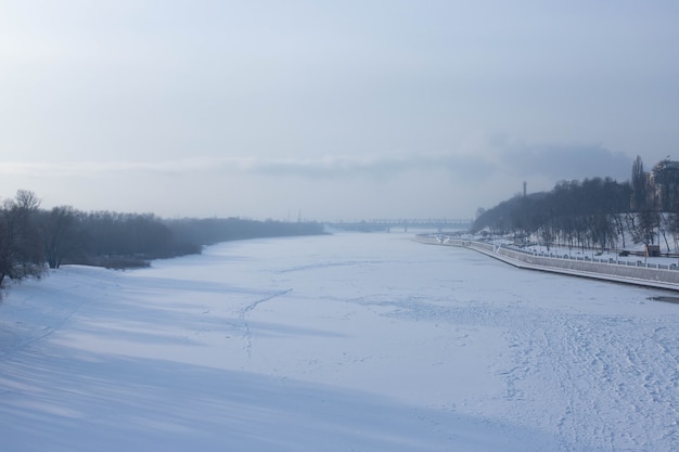 Paysage d'hiver de la rivière glacée avec brume de gel.