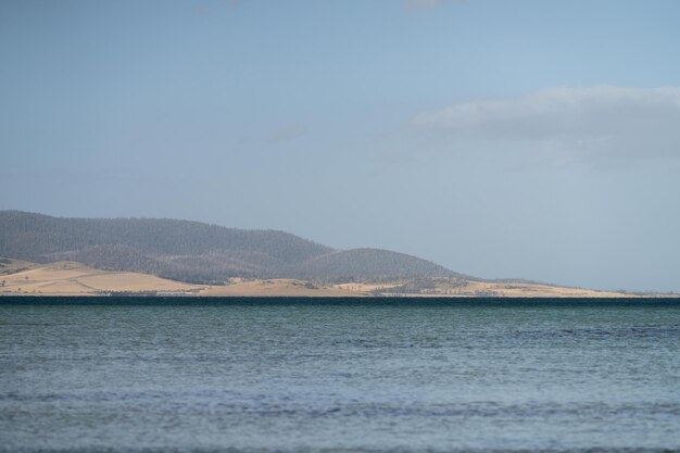 Photo paysage de l'île de la plage de tasmanie à travers l'océan