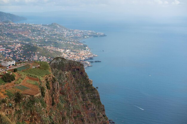 Paysage incroyable avec la ville montagneuse de Funchal, l'océan et le yacht vue d'en haut Cabo Girao Madère Vue depuis la plus haute falaise d'Europe vers Funchal