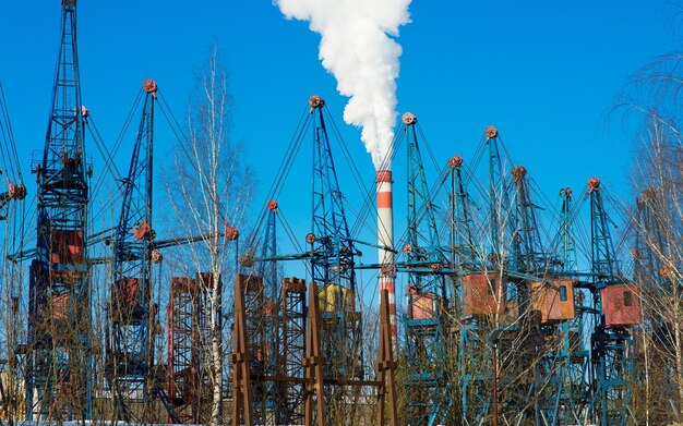 Paysage industriel, grues, tuyaux avec fumée