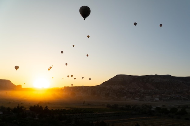 Paysage de lever de soleil de Cappadoce avec des ballons à air chaud volant dans le ciel