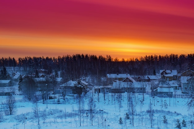 Paysage de lever de soleil d'hiver avec arbres et petite ville suédoise