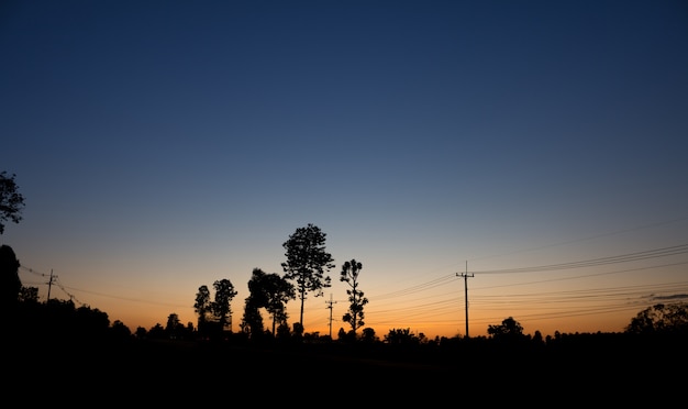 Paysage de ligne électrique avec lever de soleil et image de silhouette de fond de ciel bleu