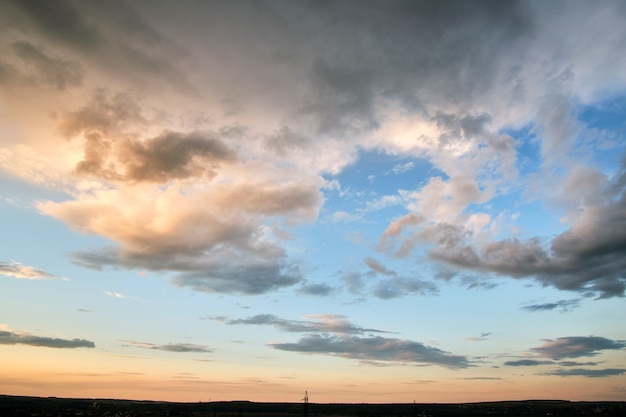 Paysage lumineux de nuages sombres sur le ciel jaune du coucher du soleil en soirée.