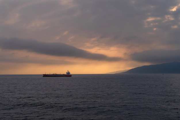 Paysage marin au coucher du soleil avec un navire marchand en arrière-plan dans le détroit de Gibraltar
