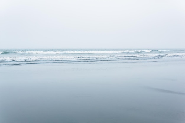 Paysage marin brumeux bord de l'océan froid avec une large plage