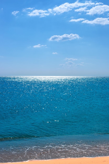 Paysage marin calme vertical Mer bleue avec plage de sable et ciel bleu avec nuages à l'horizon
