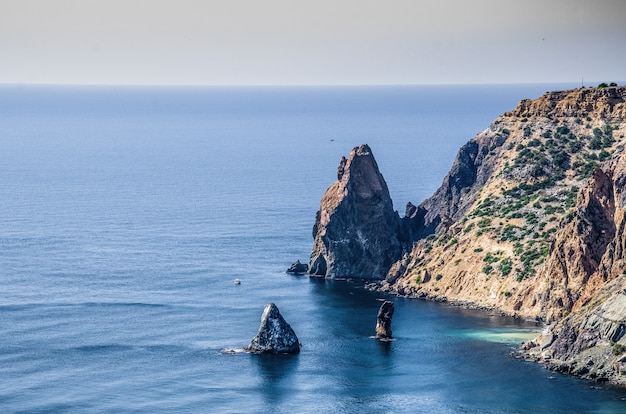 Paysage marin, ciel, montagnes, mer, grosses pierres sur la côte.