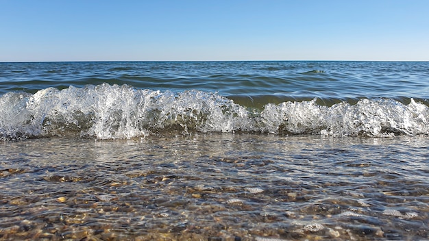 Paysage marin. Couleur azur de l'eau, vagues écumantes sur le rivage.