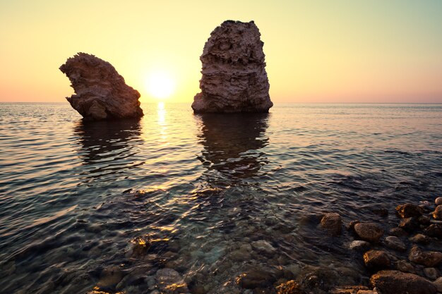 Paysage marin du rivage des eaux de mer immobiles, du fond pierreux et des rochers en mer par temps clair d'été