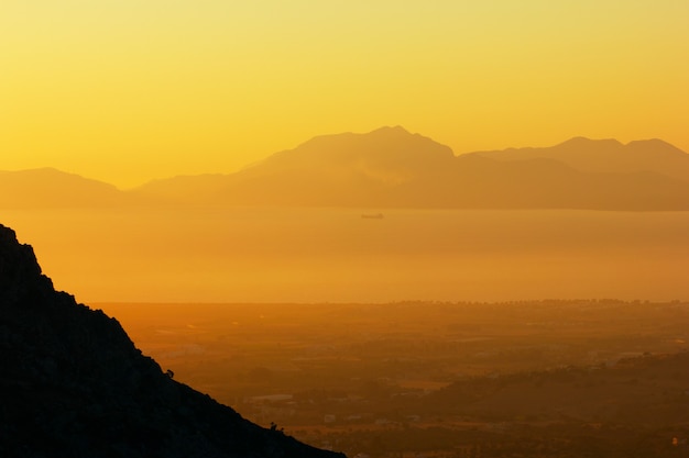 Paysage marin avec un navire au coucher du soleil