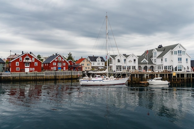 Paysage marin norvégien paysage urbain de la ville henningsvaer un petit bateau se déplace entre les péninsules sail boa