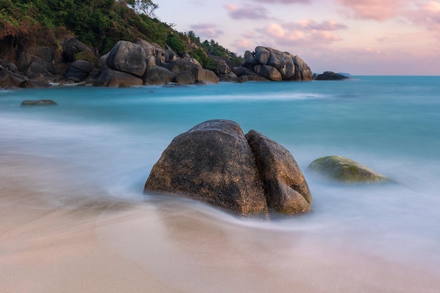 Paysage marin avec des rochers sur l'eau turquoise de la plage de sable et des nuages roses au lever du soleil Samui Thaïlande