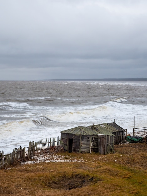 Paysage marin spectaculaire avec une mer Blanche déchaînée et une cabane de pêche sur le rivage. Baie de Kandalaksha. Umba. Russie.