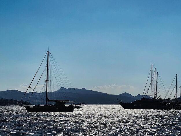 Paysage marin tranquille et concept de nature côtière bateaux de mer montagnes et ciel bleu au-dessus de l'horizon au coucher du soleil