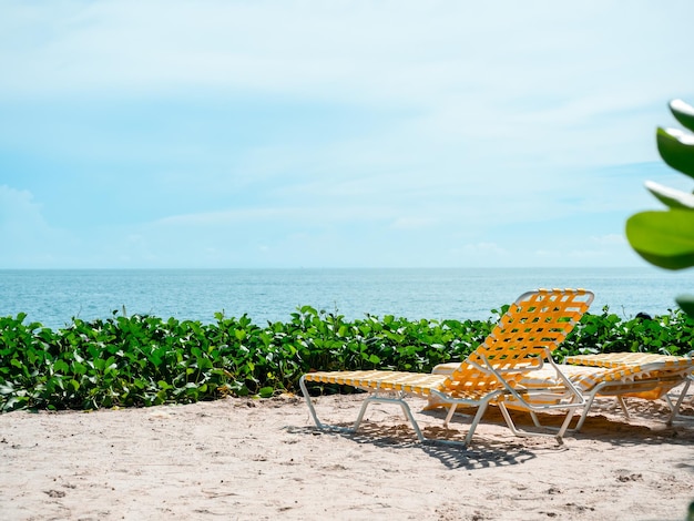 Paysage marin Vue d'été avec des transats orange avec personne sur le sable de la plage sur fond de ciel bleu par une journée ensoleillée Arrière-plans de vacances d'été avec espace de copie