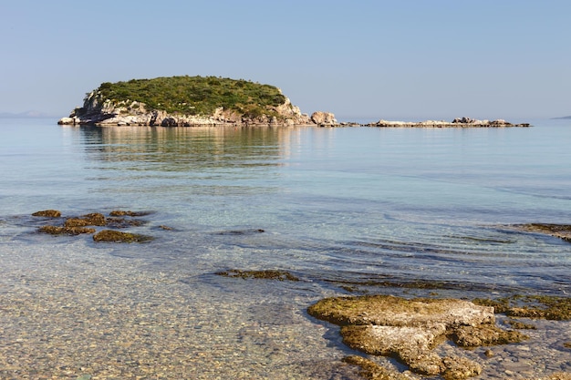 Paysage marin. Une vue sur la mer par temps ensoleillé et îlot inhabité au loin (Grèce)