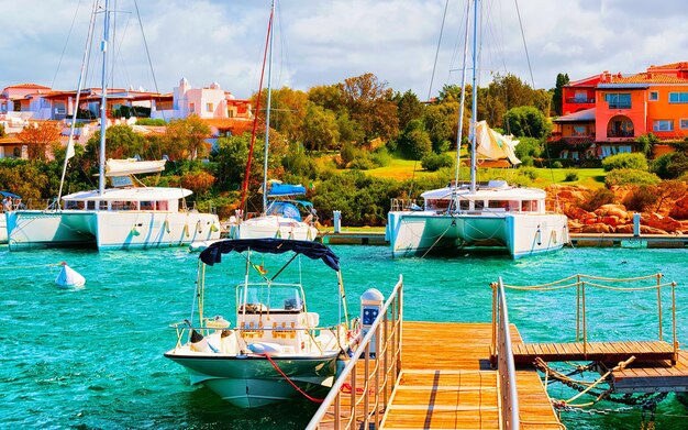 Paysage avec Marina et yachts de luxe à la mer Méditerranée de Porto Cervo en Sardaigne île d'Italie en été. Vue paysage sur le port de la ville sarde avec navires et bateaux en Sardaigne. Technique mixte.