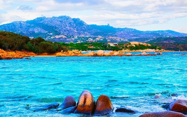 Paysage avec matinée romantique à la plage de Capriccioli sur la Costa Smeralda de la mer Méditerranée sur l'île de Sardaigne en Italie. Ciel avec nuages. Porto Cervo et province d'Olbia. Technique mixte.