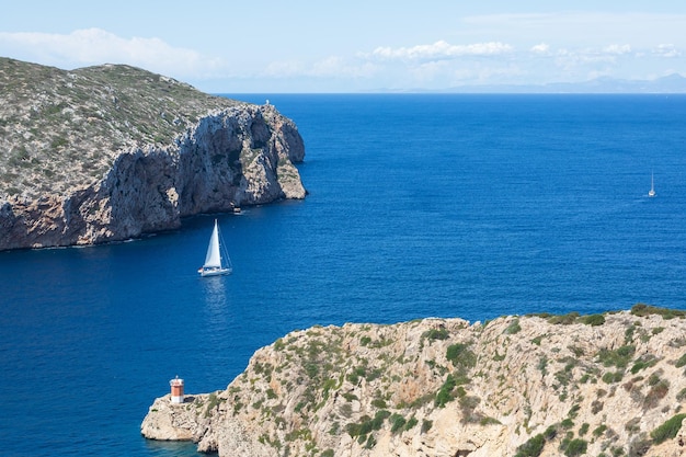 Paysage méditerranéen avec un voilier naviguant dans la baie de l'île de Cabrera Baléares