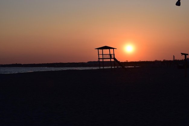 Paysage de mer au coucher du soleil Chaude journée de mars mer calme sable doux et tour de guet en bois