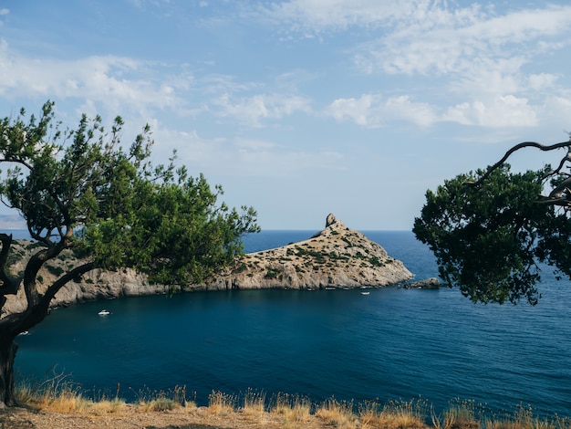 Photo paysage avec mer et montagnes avec un ciel bleu en été