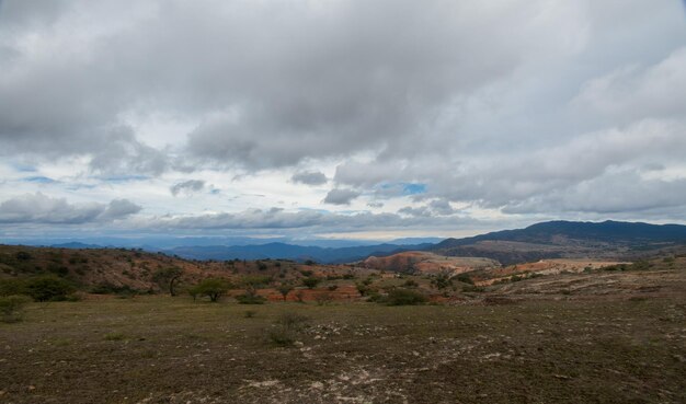 Un paysage mexicain coloré avec des montagnes rouges et un ciel nuageux à Victoria Guanajuato