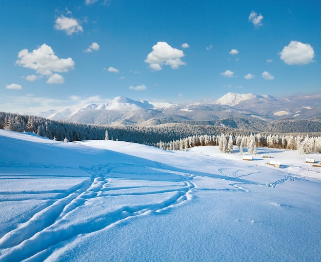 Photo paysage de montagne calme d'hiver avec un groupe de hangars et une crête de montagne derrière le mont kukol des carpates ukraine