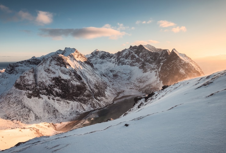 Photo paysage de montagne enneigée sur pic au coucher du soleil