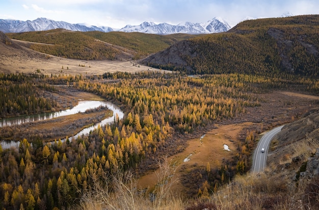 Paysage de montagne sur le fond d'une route avec une voiture et une rivière de montagne