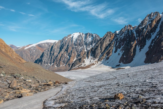 Paysage de montagne pittoresque avec glacier sous des rochers pointus au soleil Paysage impressionnant avec langue glaciaire et pinacle rocheux au soleil Belle vue sur les sommets des montagnes enneigées à très haute altitude