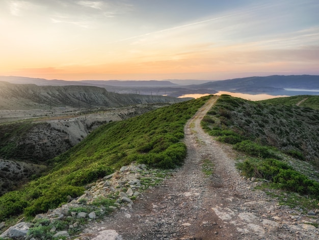 Paysage de montagne de printemps. Le chemin de montagne du matin à travers la crête monte vers le ciel à l'aube. Daghestan.