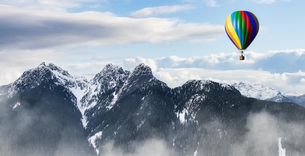 Paysage de montagne spectaculaire couvert de nuages et de vol en montgolfière