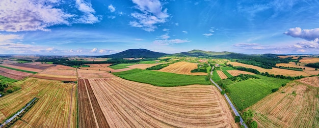 Paysage avec montagnes, champs verts et village de campagne, vue aérienne