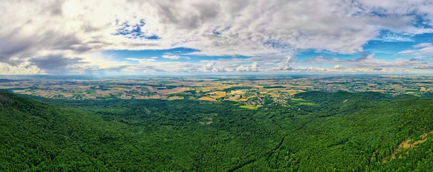 Paysage avec montagnes, champs verts et village de campagne, vue aérienne