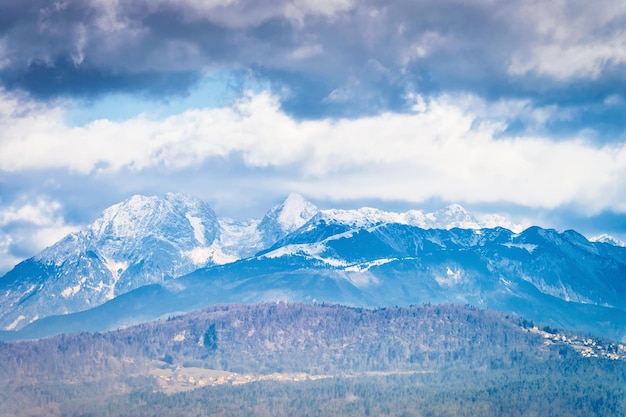 Paysage de montagnes enneigées des Alpes juliennes avec fond nature à Ljubljana en Slovénie. Sommet des collines avec nuages et vue sur le ciel. Panorama rocheux avec paysage de sentier alpin bleu. Aventure et voyage.