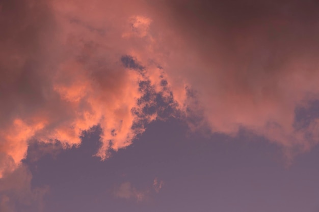 Paysage de nuages Cumulus d'été roses et bruns sur un ciel bleu pendant le coucher du soleil Fond d'écran