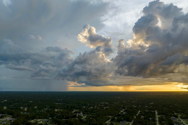 Paysage de nuages sombres et sinistres se formant sur un ciel orageux lors d'un fort orage sur la région rurale de la ville au coucher du soleil