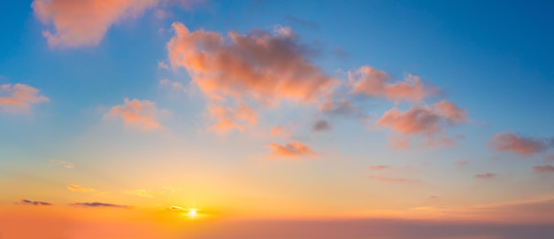Paysage nuageux pastel Levant de soleil ciel au coucher du soleil avec des nuages colorés légers sans oiseaux Avec soleil Photo panoramique grande taille