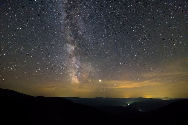 Paysage de nuit de montagnes avec ciel étoilé.