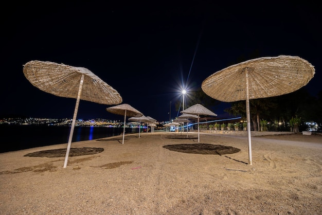 Paysage de nuit avec vue sur les parasols en osier de la plage.