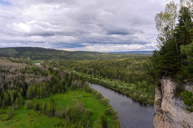 Paysage de l'Oural moyen vue depuis une haute falaise sur une vallée de la rivière vallonnée boisée au printemps