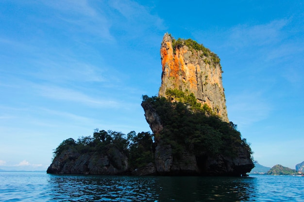 Paysage de petit rocher dans l'eau claire de l'océan contre le ciel bleu