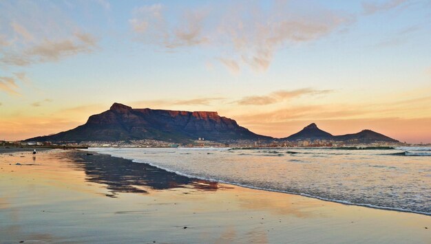 Paysage avec la plage de Milnerton et Table Mountain au lever du soleil