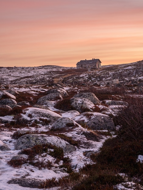 Paysage polaire du soir avec une vieille maison délabrée sur un rivage rocheux. Winter Teriberka.